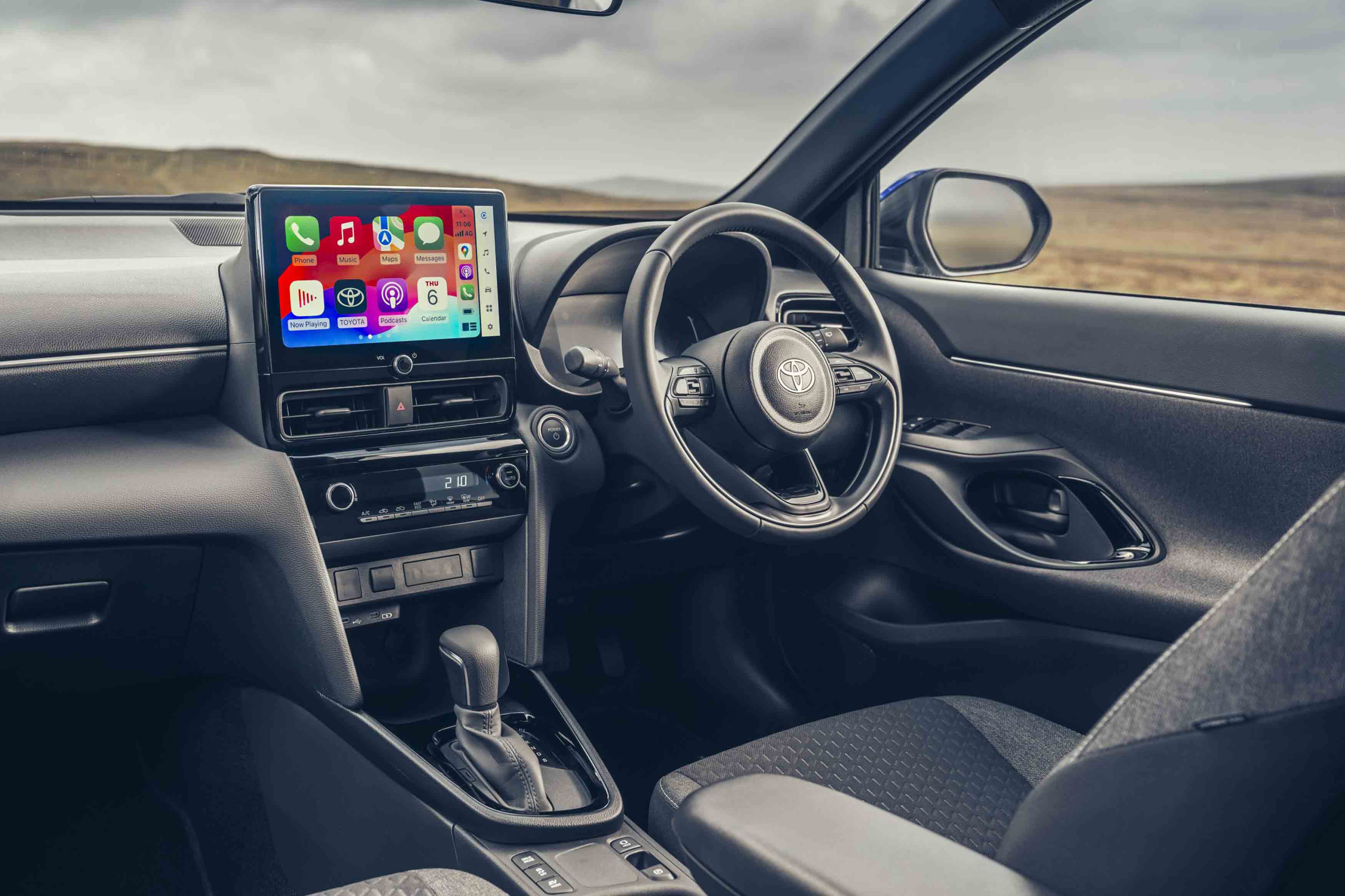 Interior dashboard view of a Toyota vehicle, showing the steering wheel, infotainment screen, and right-hand drive configuration